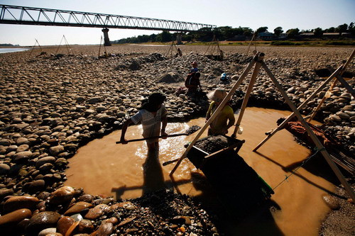 Villagers use tools to pan for gold from the Irrawaddy river near Bahalminhtin Bridge near the town of Myitkyina in the northern Myanmar