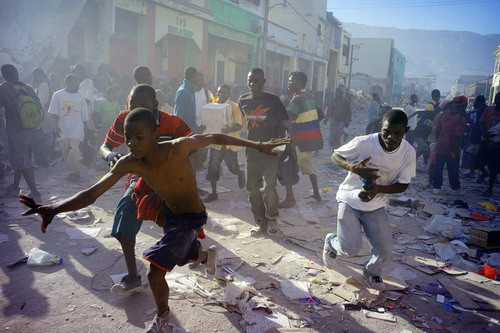 Looters run during a police assault, January 17, 2010 near the Hypolite Market in Port-au-Prince. Hundreds of rioters ransacked Hyppolite market in the heart of the devastated city as survivors besieged hospitals and make-shift field clinics, some carrying the injured on their backs or on carts