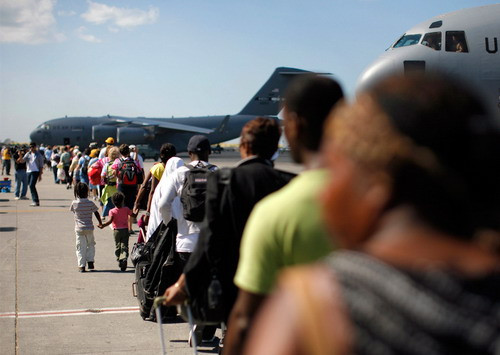 Haitian-American people line up as they board a U.S. C-17 Globemaster III plane to be evacuated from Port-au-Prince January 16