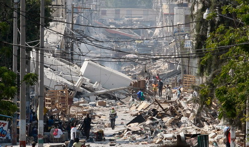 People walk on a debris-covered street in Port-au-Prince January 17