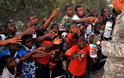 Những người sống sót trong trận động đất xin nước cứu trợ của quân độ Mỹ. Chỉ riêng hôm chủ nhật vừa qua, quân đội Mỹ đã phát hơn 9.000 chai nước và 2.000 bữa ăn. Survivors of Tuesday’s earthquake extend their arms as U.S. troops with the 82nd Airborne Division distribute water in Port-au-Prince, Sunday, Jan. 17, 2010. The troops gave out over 9,000 bottles of water and 2,000 meals Sunday.