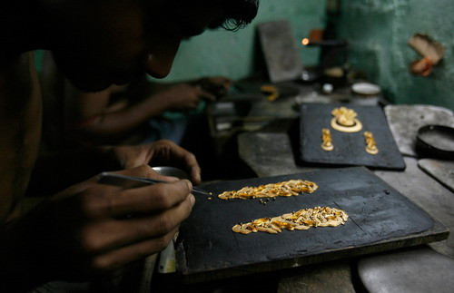 An artisan makes gold ornaments at a jewelery factory in the eastern Indian city of Kolkata