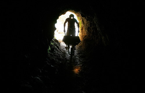 A gold miner pushes a wheelbarrow to carry rocks which will be processed for gold in an artisanal mine in Abangares, north of San Jose, Costa Rica on December 9, 2009. Costa Rica is pushing to legalize a 600 informal miners of small-scale miners who scrape out tiny amounts of gold from abandoned mine shafts using dangerous and polluting techniques.