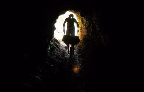 A gold miner pushes a wheelbarrow to carry rocks which will be processed for gold in an artisanal mine in Abangares, north of San Jose, Costa Rica on December 9, 2009. Costa Rica is pushing to legalize a 600 informal miners of small-scale miners who scrape out tiny amounts of gold from abandoned mine shafts using dangerous and polluting techniques.