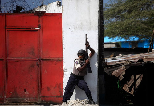 Looters run during a police assault, January 17, 2010 near the Hypolite Market in Port-au-Prince. Hundreds of rioters ransacked Hyppolite market in the heart of the devastated city as survivors besieged hospitals and make-shift field clinics, some carrying the injured on their backs or on carts