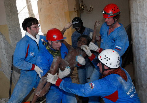 Russian rescuers carry Senvilo Ovri, 11, a survivor of the earthquake, out of the remains of a house in Port-au-Prince