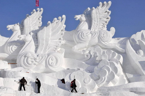 Workers shape snow sculptures prior to the Harbin Ice and Snow Festival in Harbin, China