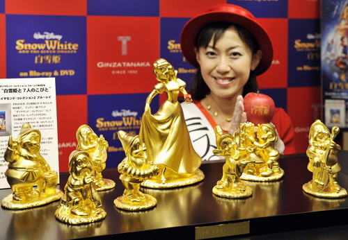 A model displays pure gold Disney character dolls showing Snow White and the seven dwarfs, priced at 30 million yen ($300,000 USD) and produced by Tanaka Kikinzoku Jewelry in Tokyo on November 4, 2009 for the promotion of Blu-ray disks of Disney movies.