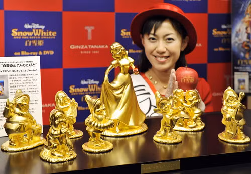 A model displays pure gold Disney character dolls showing Snow White and the seven dwarfs, priced at 30 million yen ($300,000 USD) and produced by Tanaka Kikinzoku Jewelry in Tokyo on November 4, 2009 for the promotion of Blu-ray disks of Disney movies.