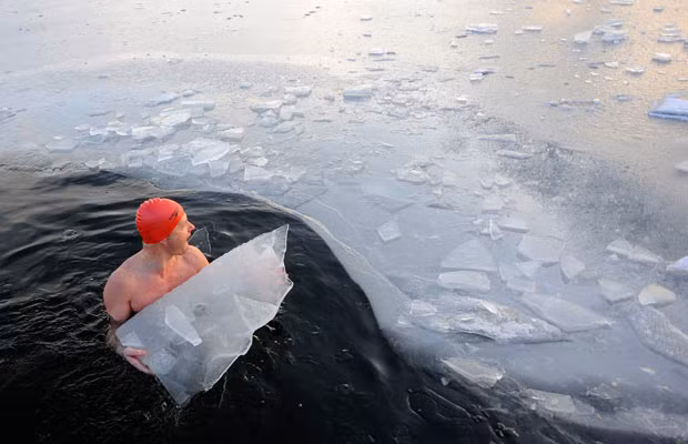 Julian Guy breaks the ice to make more room for other winter swimmers in the Serpentine in Hyde Park, London
