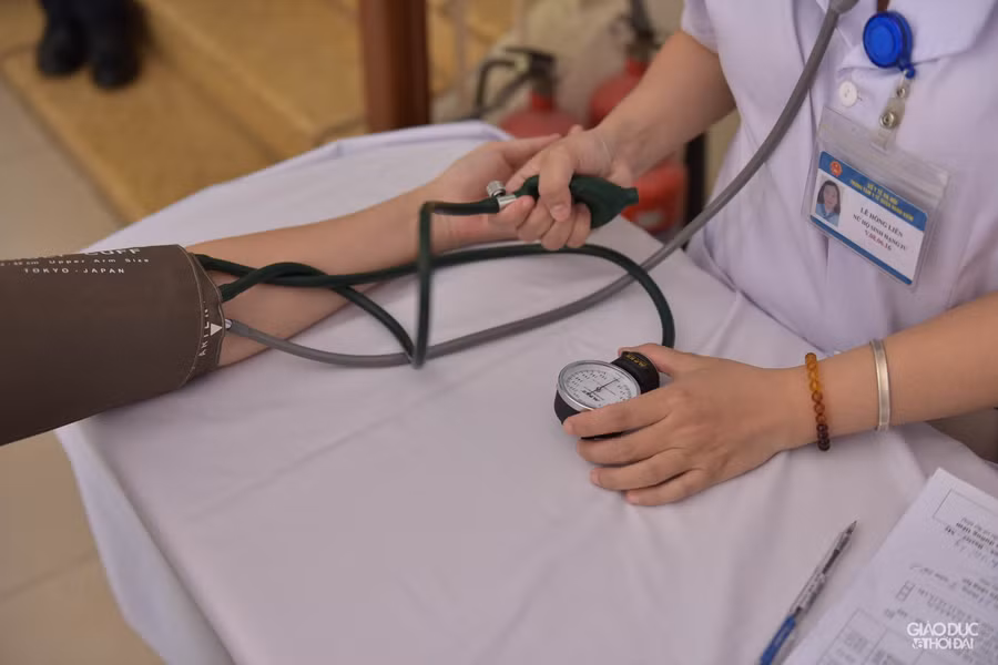 Sau khi khai y tế, người dân sẽ được khám sáng lọc trước khi tiêm.