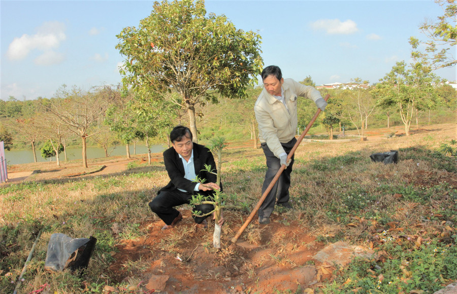 Ông Trần Ngọc Cẩm (người cầm cuốc) và đại diện phòng GD&ĐT thị xã Buôn Hồ tham gia trồng cây “Đời đời nhớ ơn Bác Hồ” năm 2023.