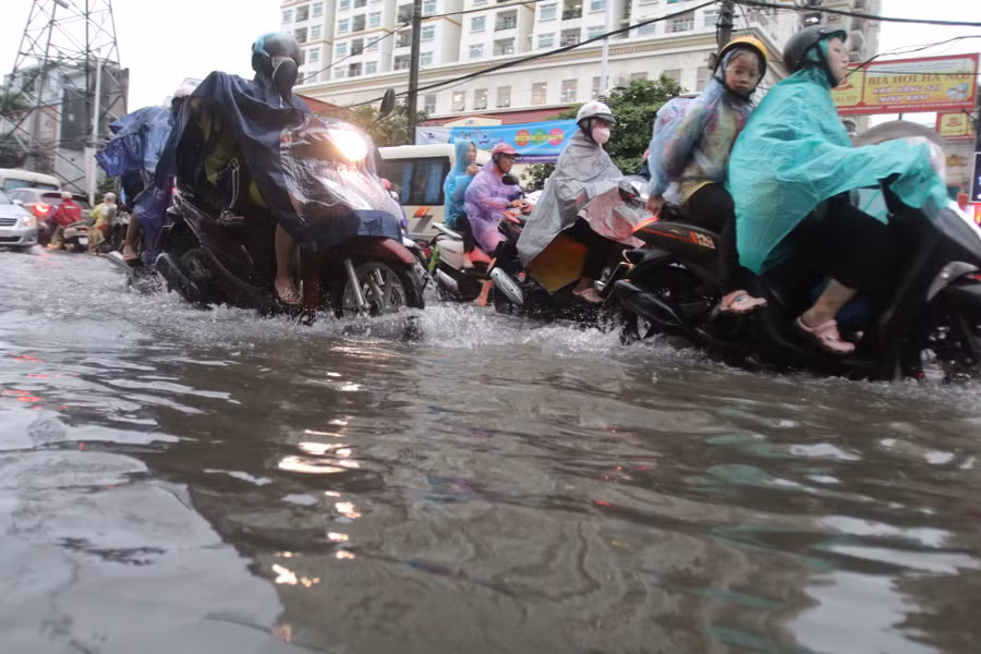 Phụ huynh, học sinh vất vả chở nhau đi học, đi làm...