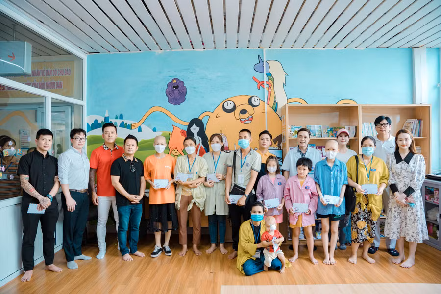 Các thành viên trong đoàn trao quà cho các bệnh nhi có hoàn cảnh khó khăn tại Bệnh viện K cơ sở Tân Triều.