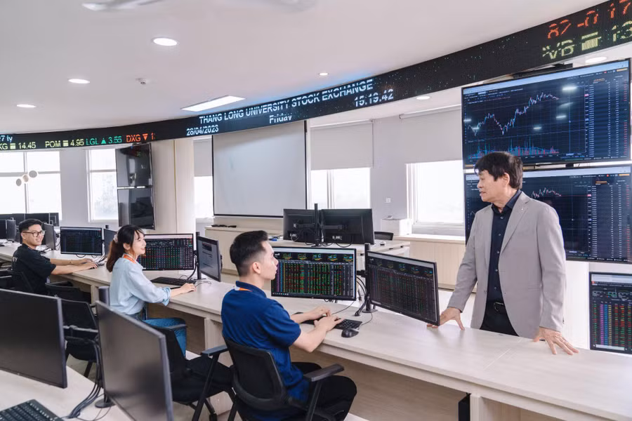 Kỹ sư Trương Ngọc Kim, Phó chủ tịch Hội đồng Trường ĐH Thăng Long cùng các sinh viên tại Trung tâm thực hành Tài chính-Ngân hàng trong trường.