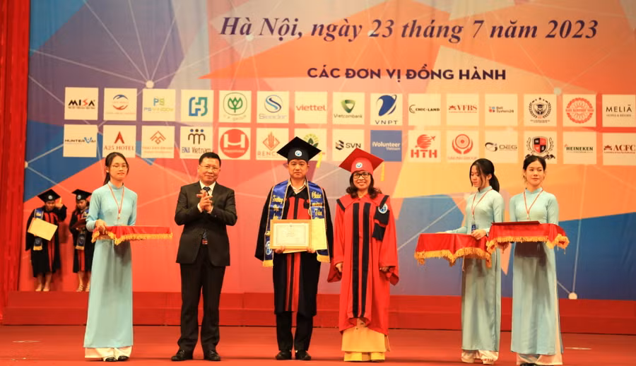 TS Trần Văn Đạt và PGS.TS Nguyễn Thị Nhung trao Bằng và Giấy khen cho các tân Thạc sĩ, Cử nhân, Kỹ sư, Kiến trúc sư có thành tích xuất sắc trong học tập và công tác lớp.