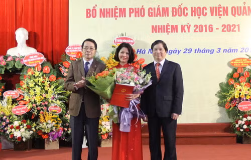 Thừa ủy quyền của Bộ trưởng Bộ GD&ĐT Phùng Xuân Nhạ, GS.TS Phạm Quang Trung - Giám đốc Học viện (bên phải) trao Quyết định cho PGS.TS Nguyễn Thị Thu Hằng