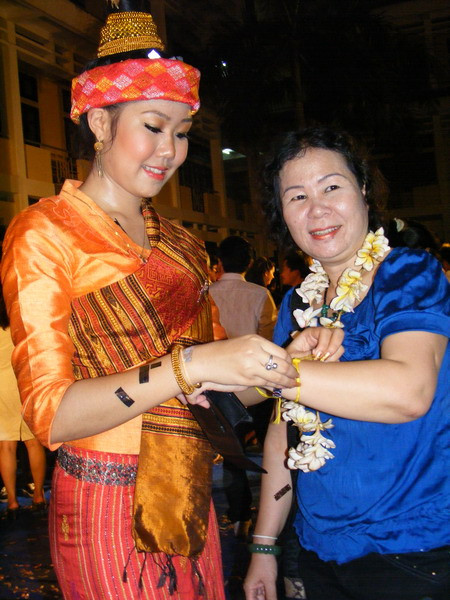 Tưng bừng tết Lào trên đất Việt ảnh 5 : Sinh viên nước bạn Lào buộc chỉ cổ tay, cầu mong hạnh phúc và sức khoẻ đến mọi người