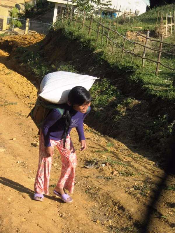 Các em bé từ nhỏ CơTu đã phải làm việc nặng nhọc để sau này dễ bắt việc hơn. 