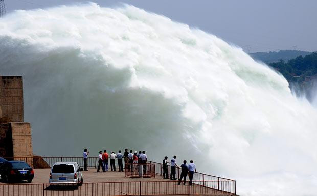 Những khoảnh khắc ấn tượng trong tuần ảnh 13 People watch torrents of water gushing out from the Xiaolangdi Reservoir on the Yellow River during a sluicing operation to clear up the sediment-laden Yellow River, in Jiyuan, central China’s Henan Province