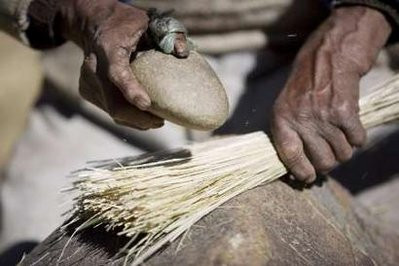 An Andean man makes rope from a local grass to be used in the construction of the Qeswachaka hanging bridge