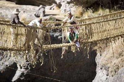 Andean men laugh as they build the Qeswachaka hanging bridge across the Apurimac river