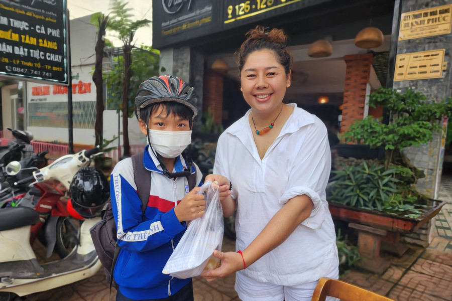 Chị Thu Nga trao tặng hộp cơm cho 1 em học sinh. (Ảnh: Thành Tâm) Chị Thu Nga trao tặng hộp cơm cho 1 em học sinh. (Ảnh: Thành Tâm)