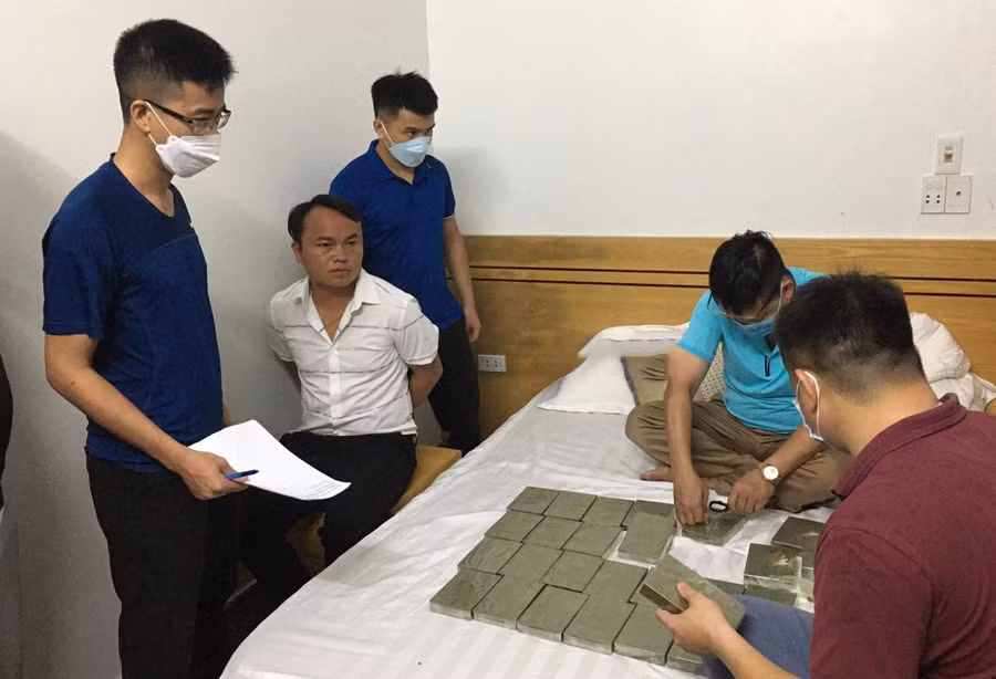 Vàng A Lềnh (áo trắng) bị cơ quan chức năng bắt quả tang cùng tang vật của vụ án.