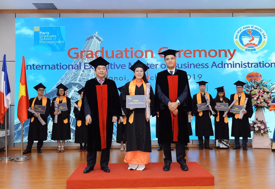 GS.TS Trần Thọ Đạt, hiệu trưởng Trường ĐH KTQD (bìa trái) cùng đại diện PGSM (bìa phải) trao bằng cho các tân thạc sĩ