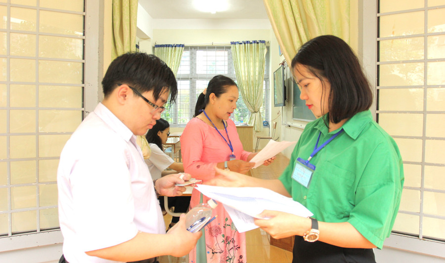 Cán bộ coi thi kiểm tra hồ sơ thí sinh trước khi vào phòng thi tại điểm thi THPT chuyên Nguyễn Du (ảnh: TT).