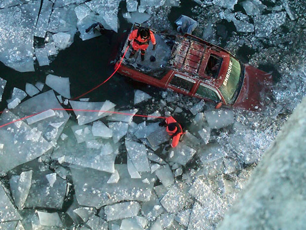 Rescue workers attend the scene of an accident in Miami, Oklahoma, USA, where an SUV packed with eight people veered off of an icy highway bridge, launching itself off a ploughed snow bank and over a guardrail before plummeting more than 80 feet into an icy river. Authorities said three people were killed and five others were injured.