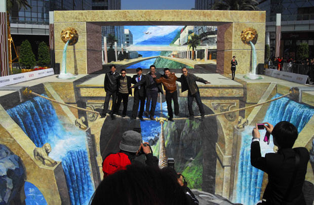 An artist has created the world’s largest 3D picture in a square in front of a shopping mall in Chongqing, China. The 3D picture, entitled ’Lion Door Valley’, measures 23.3 metres wide and 32.3 metres long, while the wall it utilises is 6.09 metres high. After being certified by Guinness World Record officials, it was named the largest 3D painting in the world. The huge image was painstakingly created by Qi Xinghua, a master from the China Central Academy of Fine Arts, who said it took him a month to complete. The painting is so lifelike that passers-by say they feel dizzy while standing on the ’ropes’ in the picture, which are strung across a huge ’hole’.