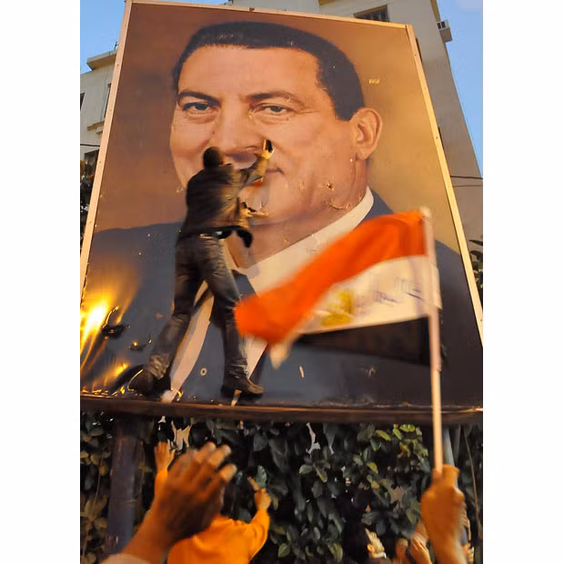 25 January 25: Demonstrators tear a portrait of President Hosni Mubarak in the northern port city of Alexandria, kicking off the revolt against his rule.