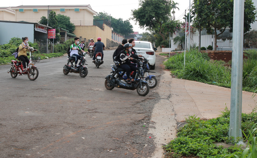 Sắp đến giờ vào lớp, nhiều em học sinh thả cho xe trôi theo dốc để lao nhanh vào cổng trường bất chấp có xe đi ngược chiều. (Ảnh: TT).