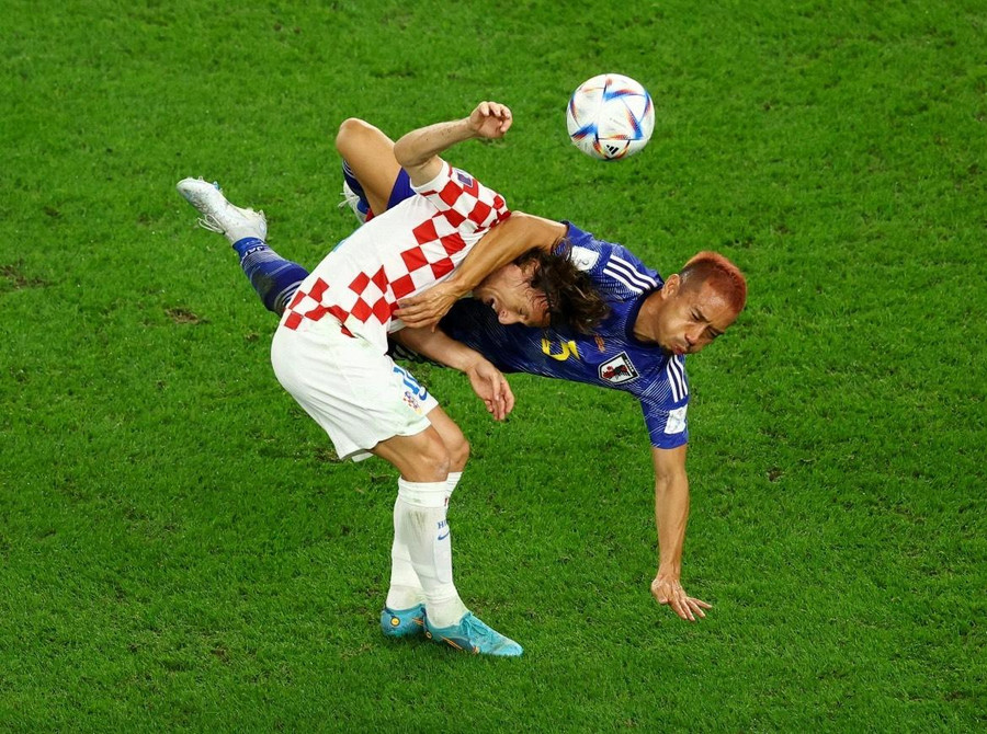 Luka Modric của Croatia và Yuto Nagatomo của Nhật Bản va chạm nhau khi tranh chấp bóng. Ảnh: Lee Smith/Reuters.