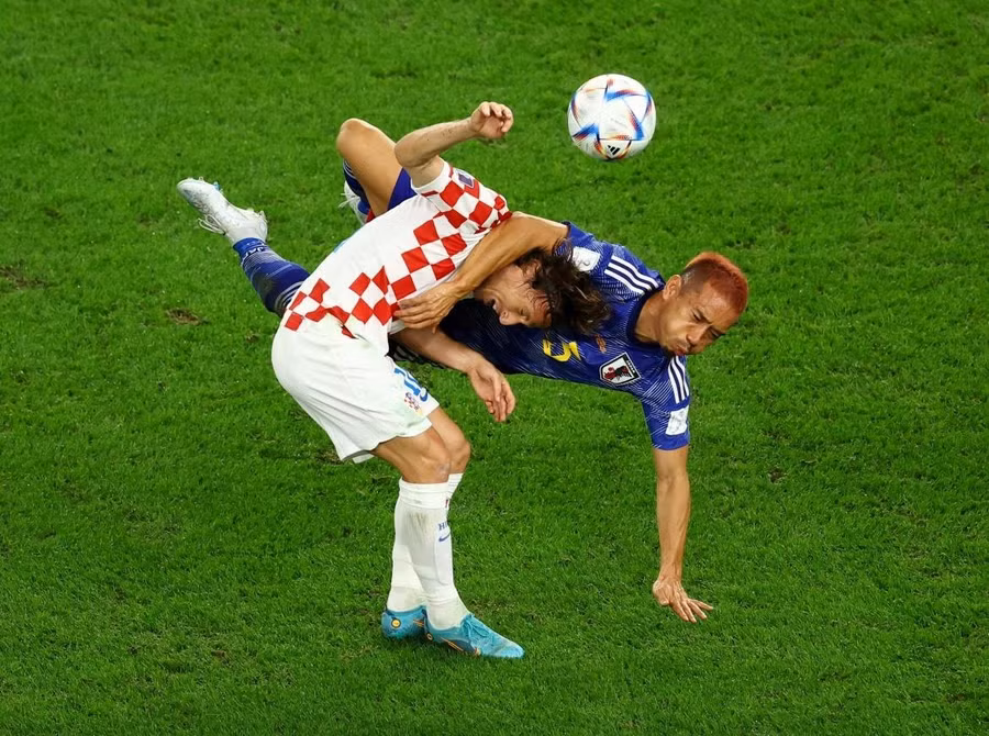 Luka Modric của Croatia và Yuto Nagatomo của Nhật Bản va chạm nhau khi tranh chấp bóng. Ảnh: Lee Smith/Reuters.