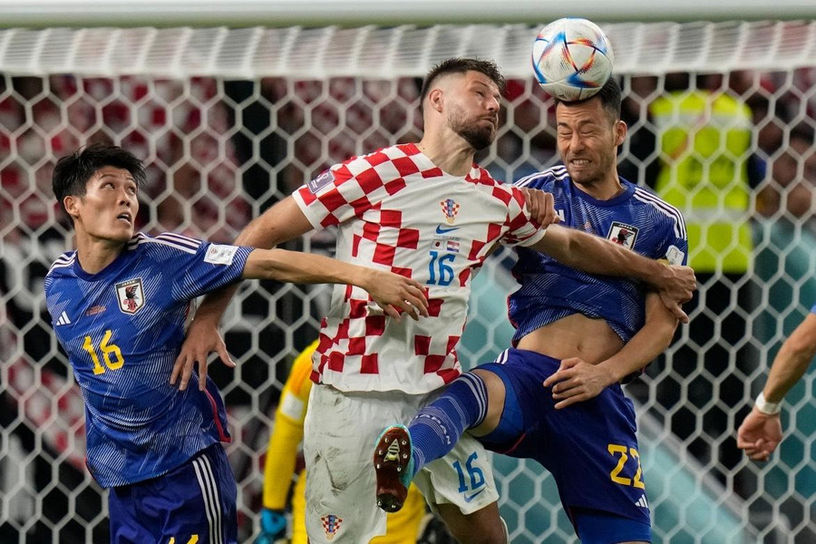 Maya Yoshida và Takehiro Tomiyasu tranh bóng với Bruno Petkovic. Ảnh: Alessandra Tarantino/Reuters.