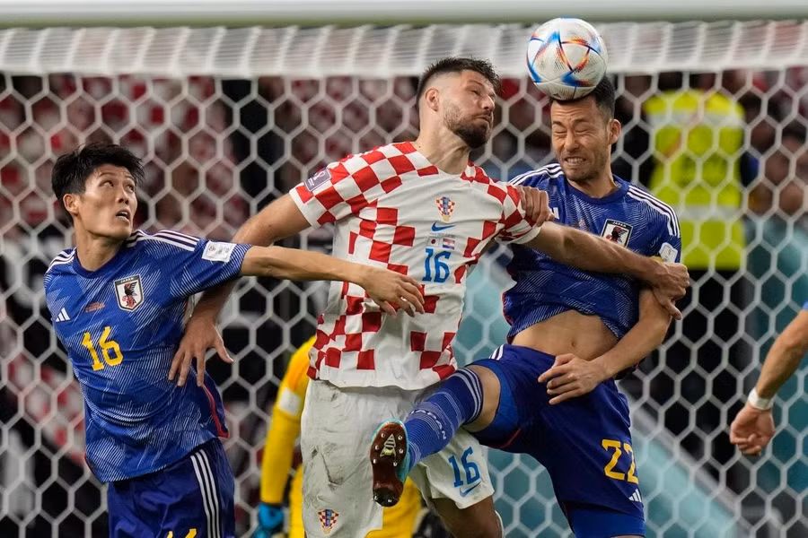 Maya Yoshida và Takehiro Tomiyasu tranh bóng với Bruno Petkovic. Ảnh: Alessandra Tarantino/Reuters.