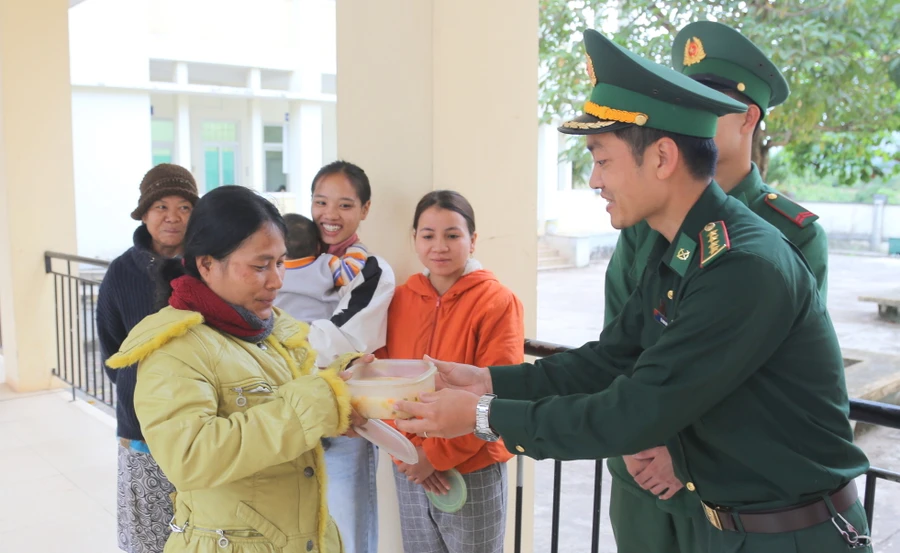 Đại úy Lê Anh Quốc, Bí thư Đoàn Đồn Biên phòng cửa khẩu quốc tế La Lay trao cháo cho bệnh nhân.