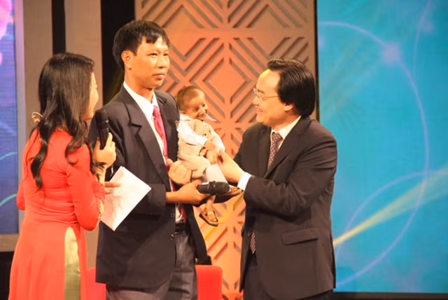 Cậu học trò tí hon tươi cười khi được Bộ trưởng bế