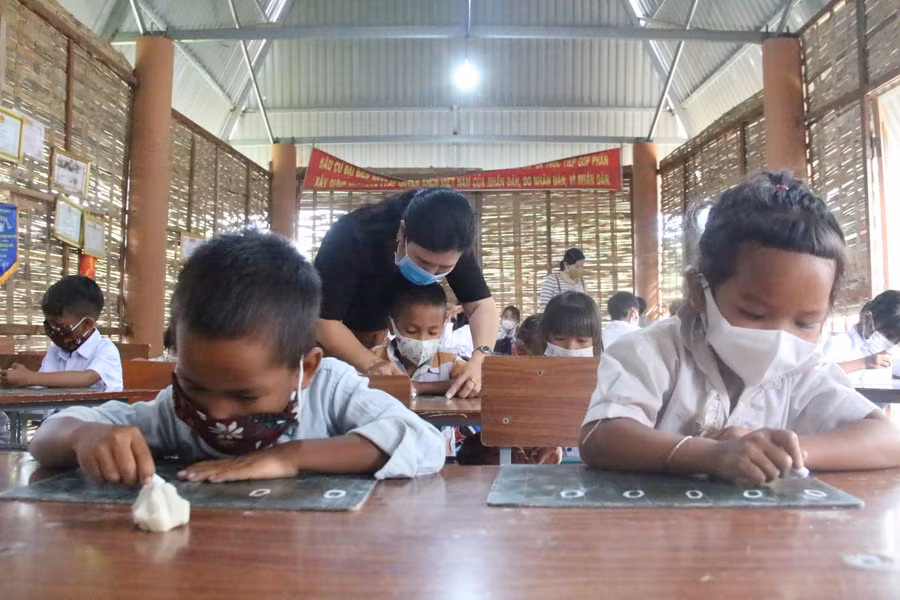 Học sinh trường Tiểu học Đặng Trần Côn học tạm trong nhà rông của thôn khi dịch bệnh Covid-19 diễn biến phức tạp.