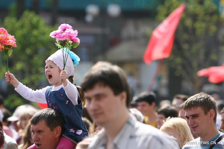 Thế giới kỷ niệm Ngày Quốc tế Lao động 2013 ảnh 2 A child attends a rally marking May Day in Kiev, Ukraine, on May 1, 2013. Over 15,000 Ukrainian Communists held a rally marking May Day in the center of Kiev. (Xinhua/Mu Liming)