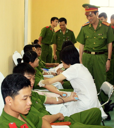 Phó hiệu trưởng Đoàn Việt Mạnh đang động viên học viên, chiến sĩ trong lúc lấy máu. Ảnh: gdtd.vn