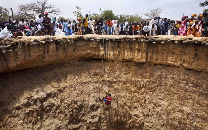 Trẻ em xúc động bên cạnh vợ chồng Kim Jung-Un ảnh 1 A man descends into a large former well during a traditional ceremony in the village of Ndande. Every year, inhabitants of the village take part in a Sufi Muslim ceremony called Gamou-Ndande. The ceremony combines nights of praying and chanting as well as traditionally animist ceremonies. The well, called Kalom, was the site of historic battles in Senegalese history. According to local historian Baye Niass, the well dates back to the 16th century. Today there is no water in the former well and it is used for ceremonial purposes. Niass says the well measure 36 meters in depth an 11m in diameter