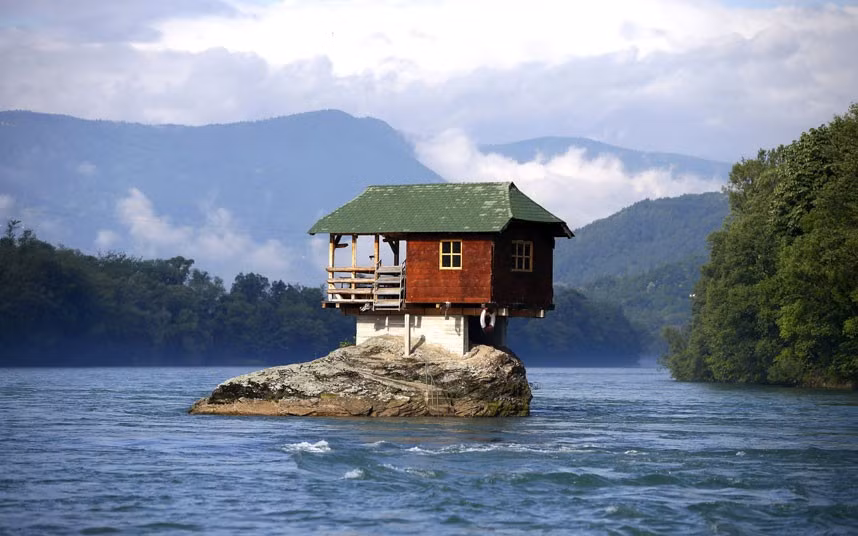 Trẻ em xúc động bên cạnh vợ chồng Kim Jung-Un ảnh 2 A house built on a rock on the river Drina near the western Serbian town of Bajina Basta. The house was built in 1968 by a group of young men who decided that the rock on the river was an ideal place for a tiny shelter.