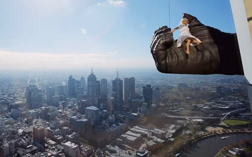 Trẻ em xúc động bên cạnh vợ chồng Kim Jung-Un ảnh 5 Stunt expert Leigh-Anne Vizer is held by a 4.5 metre King Kong hand 300 metres above the city of Melbourne during a ’King Kong’ production photo call at Eureka Skydeck in Melbourne, Australia. Eureka Skydeck gave permission for the construction of the large Kong hand to offer visitors the King Kong Experience at Eureka Sydeck over the next 9 months. The King Kong show is set to open in June in Melbourne and Eureka Skydeck is the tallest building in the southern hemisphere.