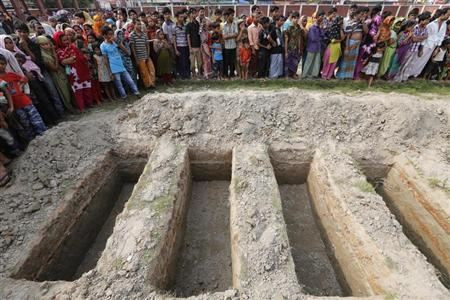 Workers dig mass graves during a mass burial of unidentified garment workers, who died in the collapse of the Rana Plaza building in Savar, in Dhaka May 1, 2013