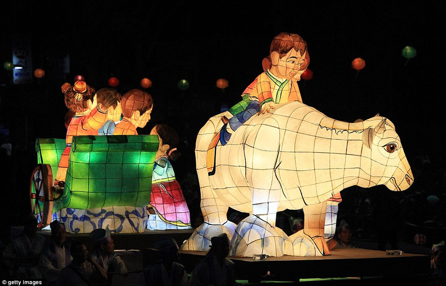 A lantern depicting a boy riding a cow is carried down a Seoul street as part of the Buddha birthday celebrations Read more: http://www.dailymail.co.uk/news/article-2323047/South-Korea-lit-sea-lanterns-Seoul-prepares-mark-Buddha-s-birthday.html#ixzz2T5UuRkoh Follow us: @MailOnline on Twitter | DailyMail on Facebook