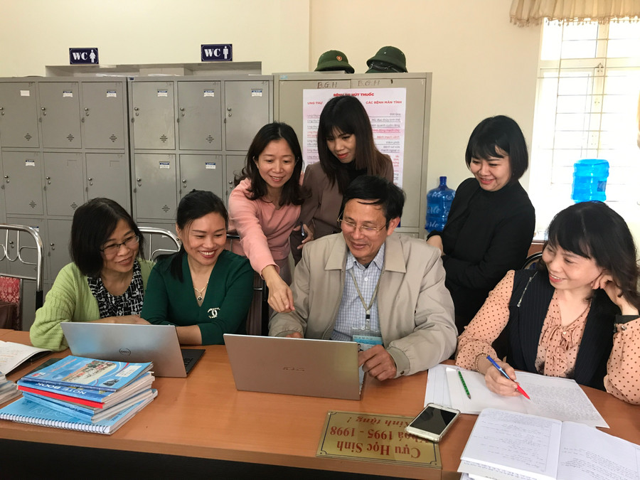 Nhà giáo Lưu Hải Tiền trao đổi chuyên môn với các đồng nghiệp trong trường.