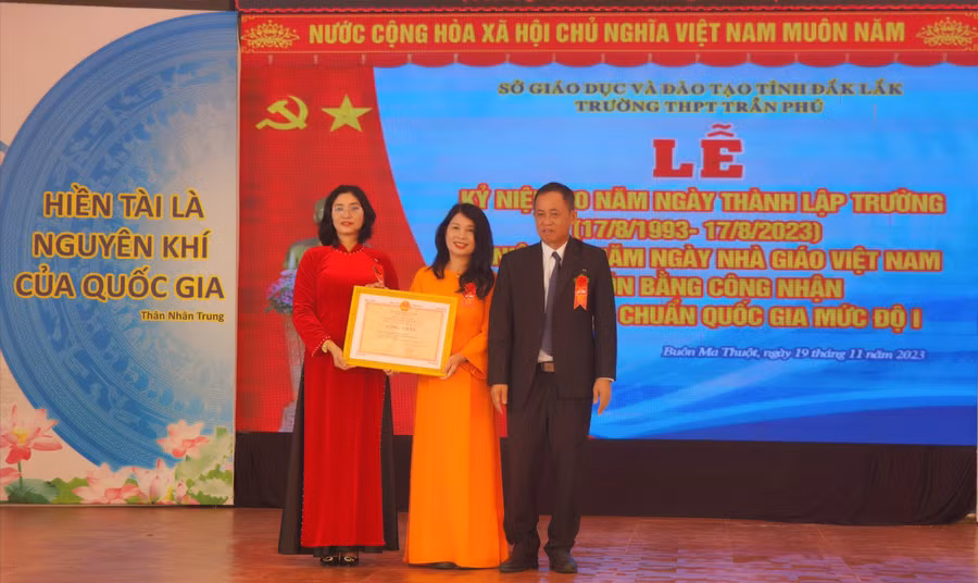 Thừa ủy quyền của UBND tỉnh Đắk Lắk, Phó Giám đốc Sở GD&ĐT Đỗ Tường Hiệp trao Bằng công nhận đạt chuẩn quốc gia mức độ 1 cho Ban Giám hiệu Trường THPT Trần Phú. (Ảnh: TT)